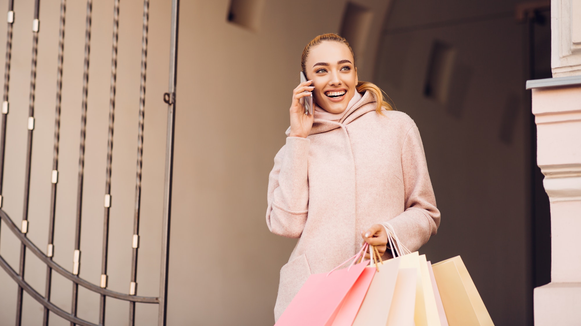 Young woman talking on phone after shopping in boutiques